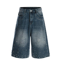 Blue denim shorts with pearl embellishments on a white background