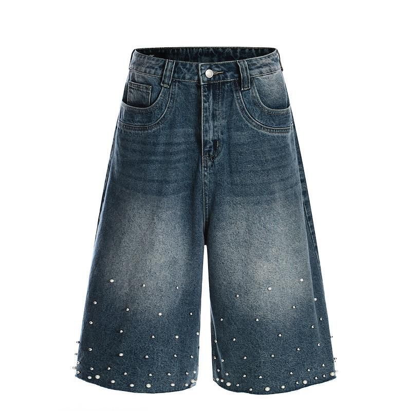Blue denim shorts with pearl embellishments on a white background