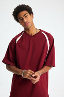 Man wearing a maroon sports jersey with white accents on a white background