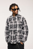 Person wearing a black and gray plaid shirt with sunglasses on a white background
