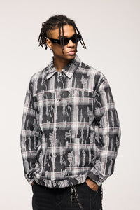 Person wearing a black and gray plaid shirt with sunglasses on a white background