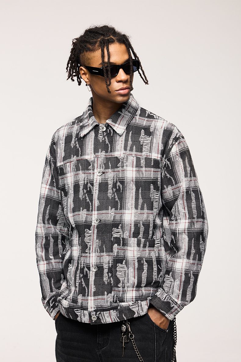 Person wearing a black and gray plaid shirt with sunglasses on a white background