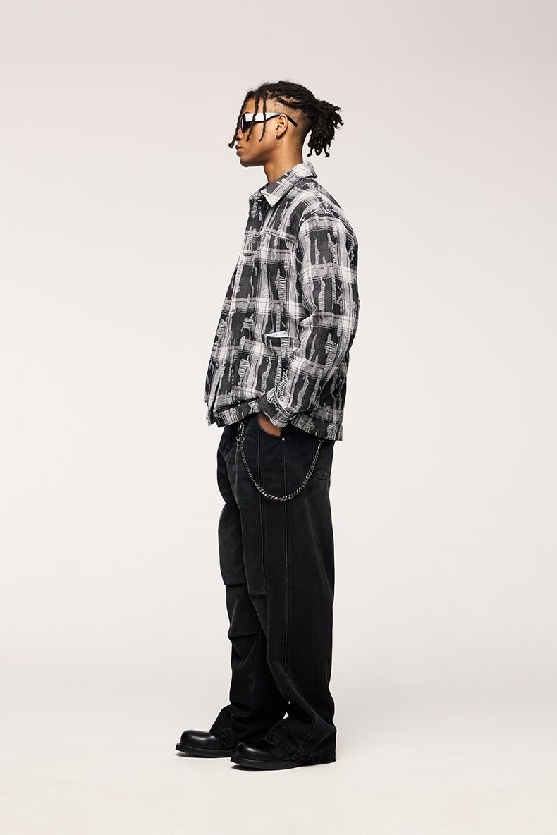 Person wearing a plaid shirt and black pants on a white background